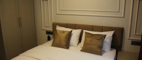Una habitación de hotel con cama, mesita de noche y armario.
