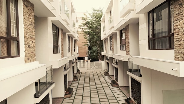 Un edificio moderno con un patio central, que presenta un camino empedrado y detalles de piedra en las paredes.