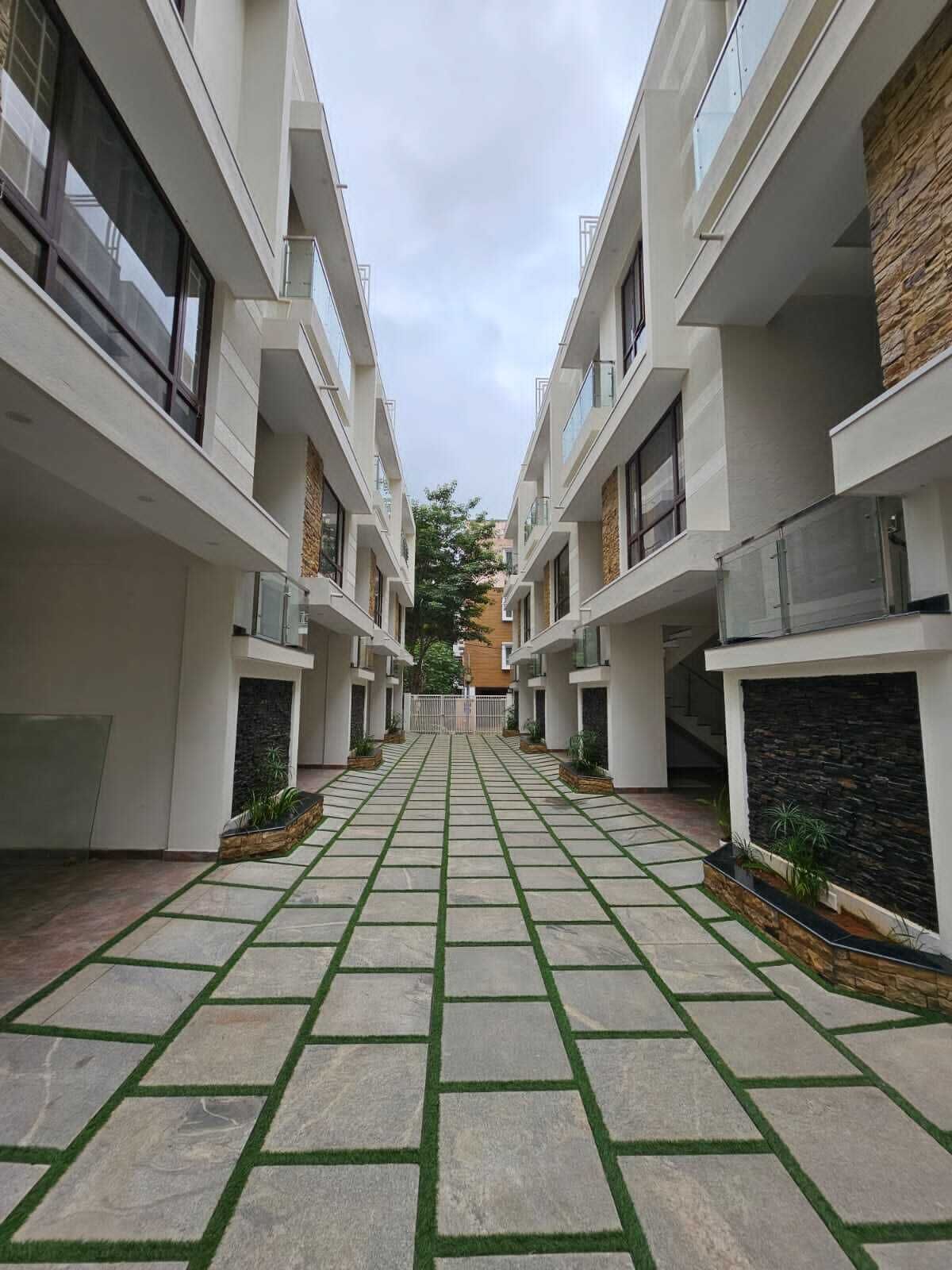A modern building with a central courtyard featuring a stone and grass pathway.