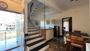 Una cocina moderna con estufa integrada, refrigerador y zona de comedor con mesa y sillas.
