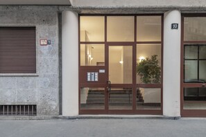 A building entrance with a glass door, a staircase, and a number '10' sign. - BnButler - Mussi, 10 (Milano)