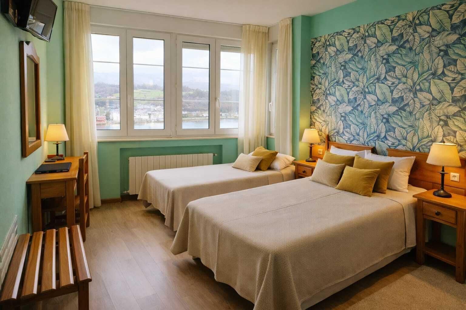Une chambre d’hôtel avec deux lits, un bureau, une chaise, un radiateur et une fenêtre donnant sur un beau paysage.