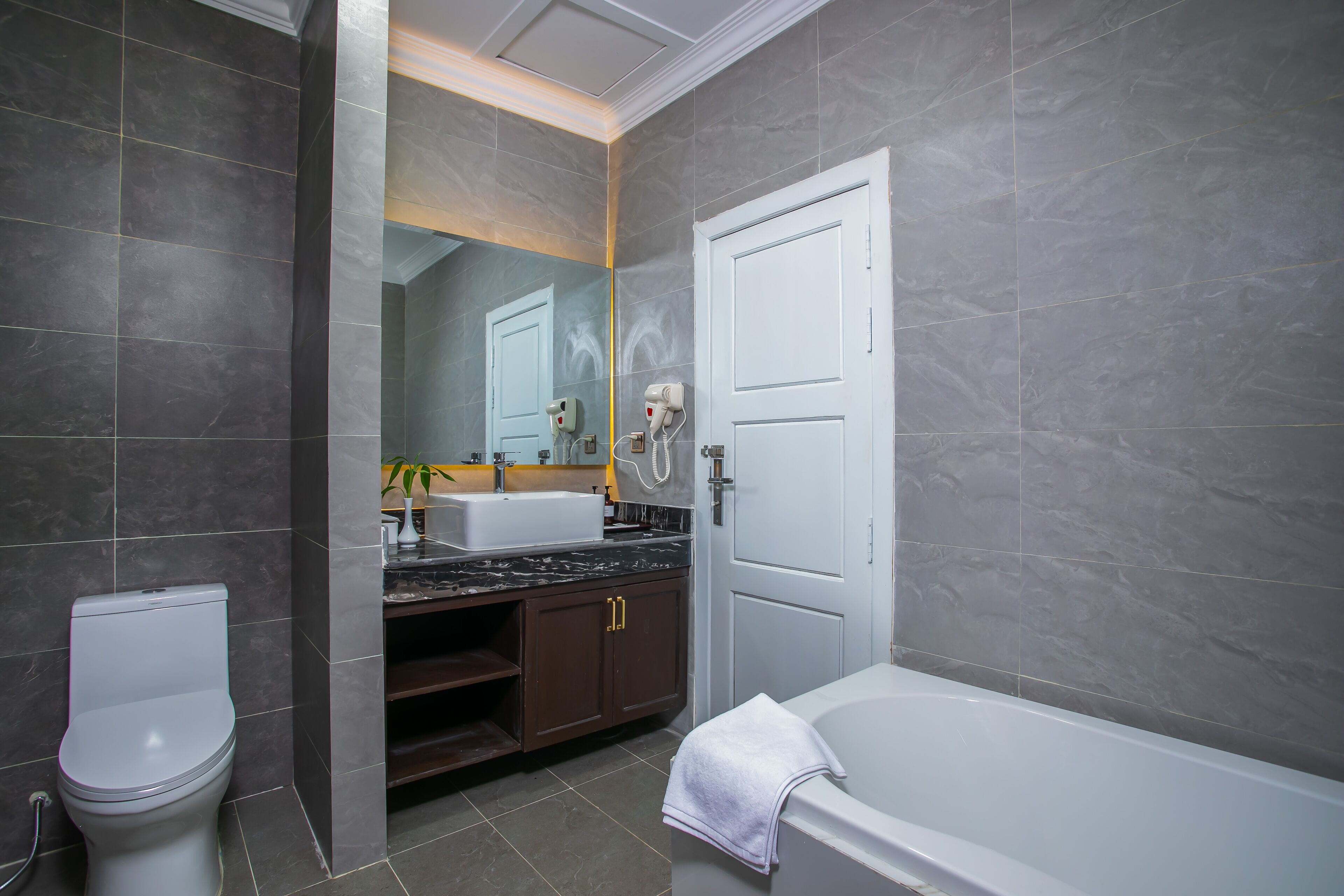 A modern bathroom with a toilet, sink, and bathtub.