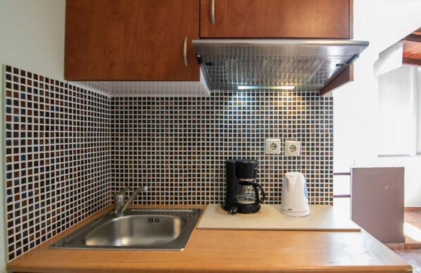 A kitchen with a stainless steel sink, a coffee maker, and a microwave on the countertop. - Room in Guest Room - Girogiali Beach Hotel (Chania)