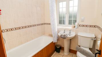 Une salle de bain avec une baignoire, un lavabo et des toilettes.