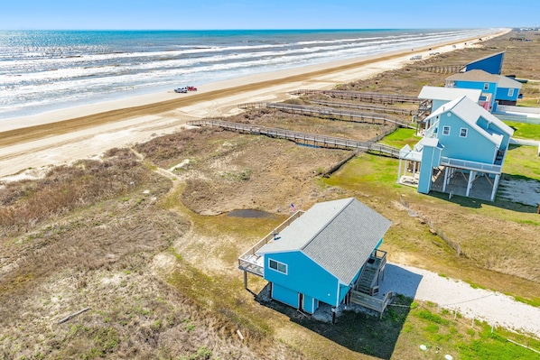 Propiedad costera con vista a la playa, un muelle y varias casas.