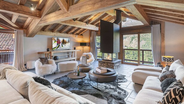 A spacious living area with a high ceiling, wooden beams, a fireplace, a television, and a view of the outdoors. - Renovated chalet with pool, sauna and hammam for 14 people in Saint-Martin-de-Belleville (Saint-Martin-de-Belleville)