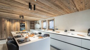 A modern kitchen with a central island, wooden ceiling, and white cabinetry. - Renovated chalet with pool, sauna and hammam for 14 people in Saint-Martin-de-Belleville (Saint-Martin-de-Belleville)