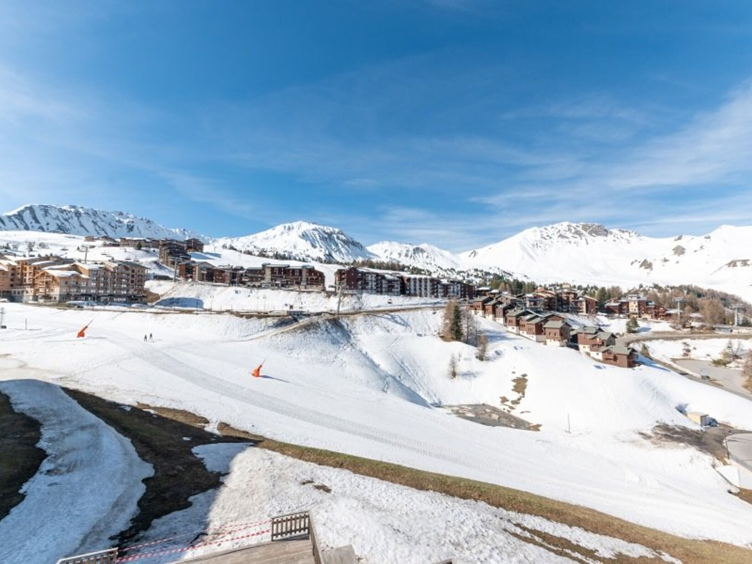 Een besneeuwde bergstad met gebouwen en een skipiste.