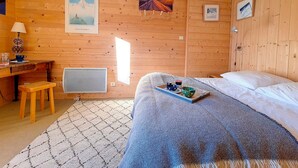 Ein gemütlicher Holzraum mit einem Bett, einem Schreibtisch und einer Heizung.