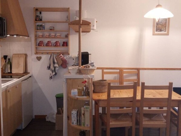 Enjoy cooking in this fully equipped kitchen with a shelf, cabinet, and hanging light fixture.