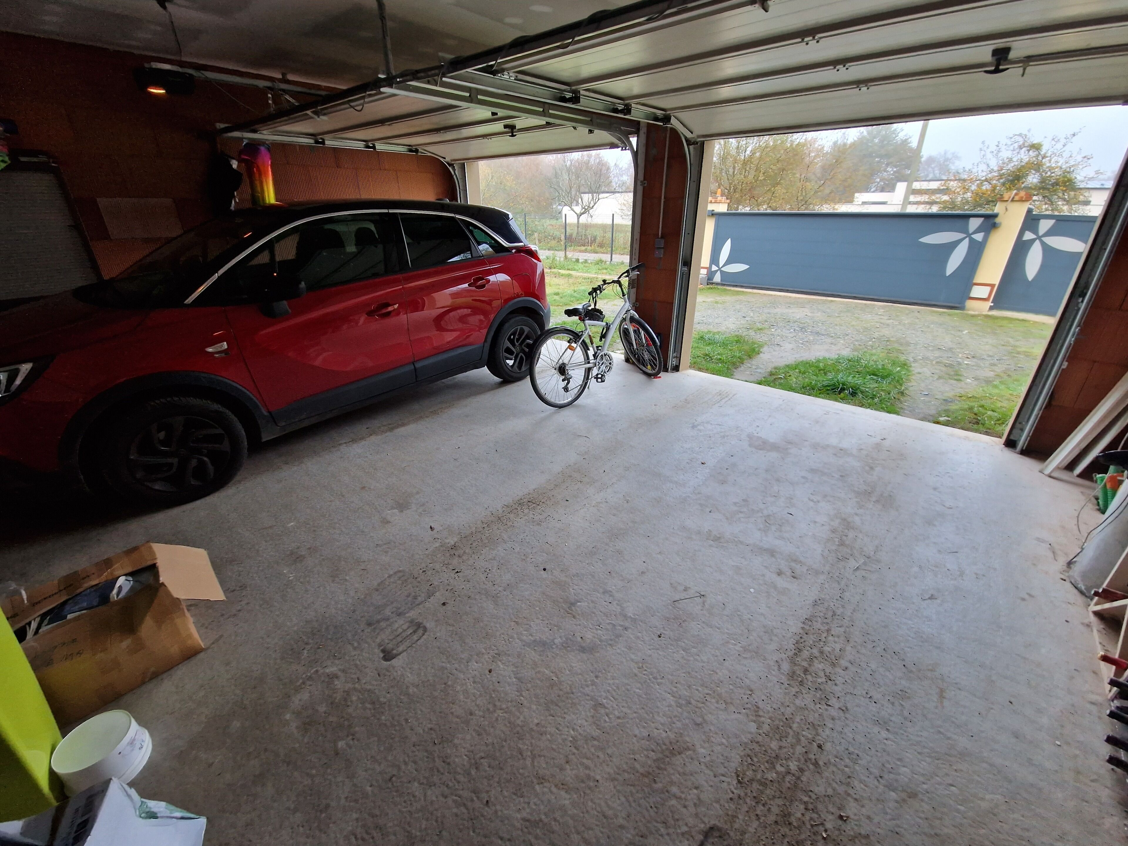 A garage with a red car and a bicycle.