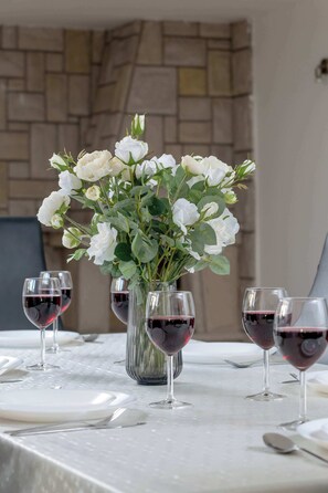A table set with white roses in a vase, surrounded by wine glasses. - Spacious Apartment for 7 Persons | Close to Krupówki Street (Zakopane)