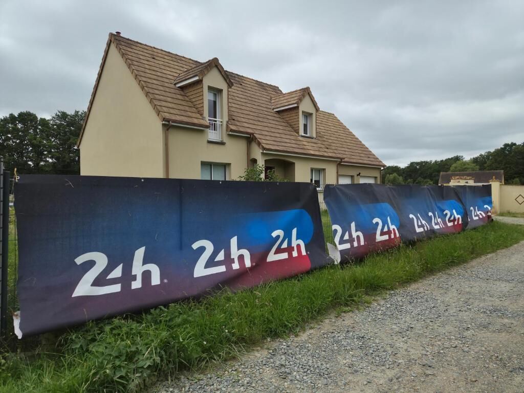 Une maison avec un toit en pente et une façade de couleur beige.