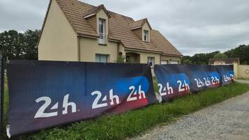 Une maison avec un toit en pente et une façade de couleur beige.