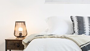 A neatly made bed with a white comforter and a patterned throw blanket. - Chic Sailboat Bend Condo w/Parking, Near Riverwalk (Fort Lauderdale)
