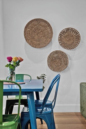 A dining area with a table, chairs, and wall-mounted woven placemats. - Chic Condo w/ Patio, Near Fort Lauderdale Hotspots (Fort Lauderdale)