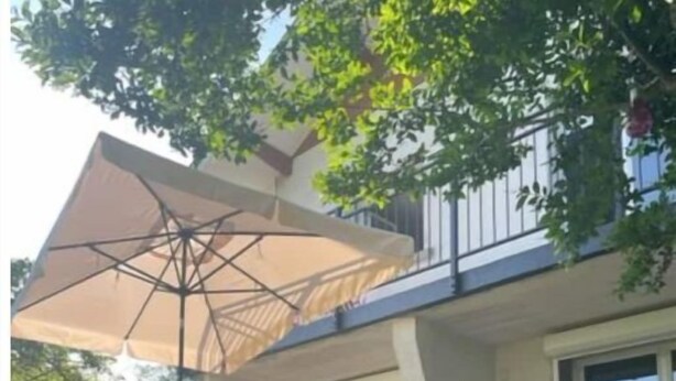 An outdoor patio with a table and chairs, a large umbrella, and a grill. - La Parenthèse Gîte 3 Étoiles à la Campagne (Fougerolles-Saint-Valbert)