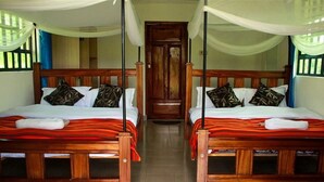 A room with two wooden beds, each with a canopy and pillows. - Iretet Mara Lodge (Maasai Mara)