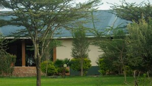 A building with a green roof and a garden with various trees and shrubs. - Iretet Mara Lodge (Maasai Mara)