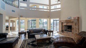 A spacious living room with a fireplace, a large sofa, and a coffee table. - Spacious Golf Course Retreat on Hogan (Lake Havasu City)