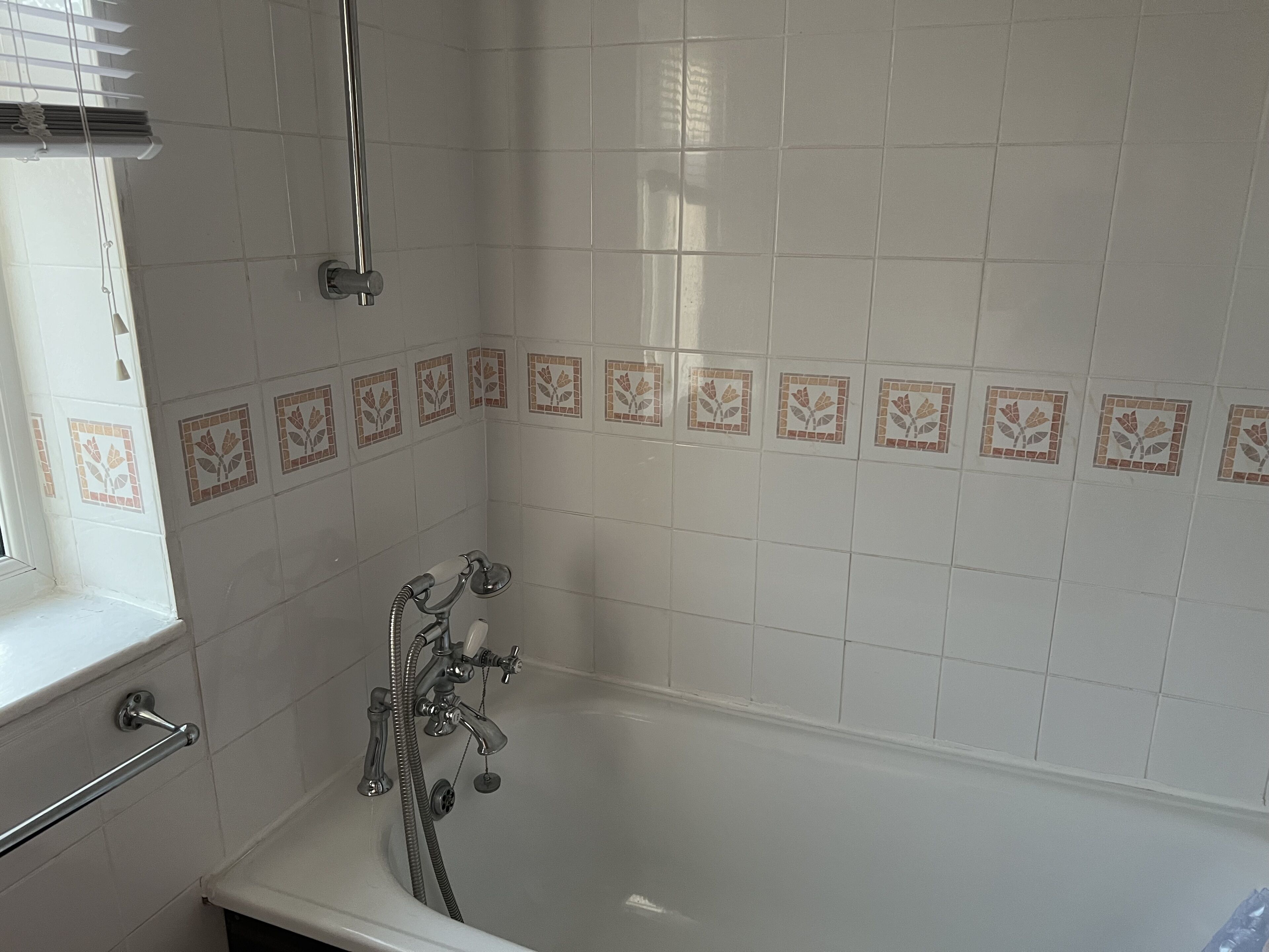 Une salle de bain avec une baignoire, une douche et une fenêtre.