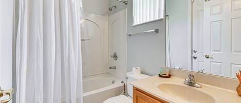 A bathroom with a bathtub, toilet, and sink.