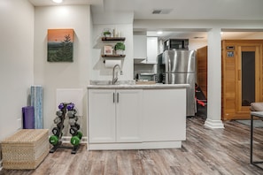 A modern kitchen with white cabinets, a stainless steel refrigerator, and a microwave. - Chic Minneapolis Apt - 6 Blocks to Lake Nokomis! (Minneapolis)