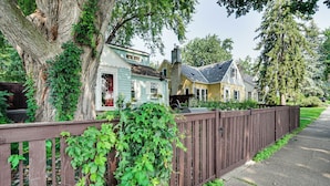 A row of houses with a wooden fence and a tree with green leaves. - Chic Minneapolis Apt - 6 Blocks to Lake Nokomis! (Minneapolis)