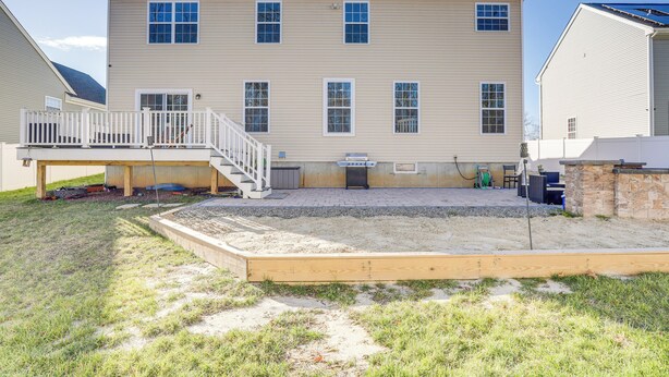 A two-story building with a covered patio area and a wooden deck. - Spacious Ewing Township Home: Home Gym & Deck! (Trenton)