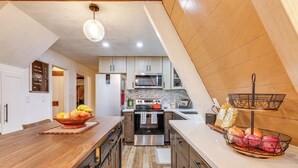 A modern kitchen with wooden cabinets, a stainless steel oven, and a wooden countertop. - 3 Mi to Calaveras Big Trees: Cabin w/ Fire Pit! (Arnold)