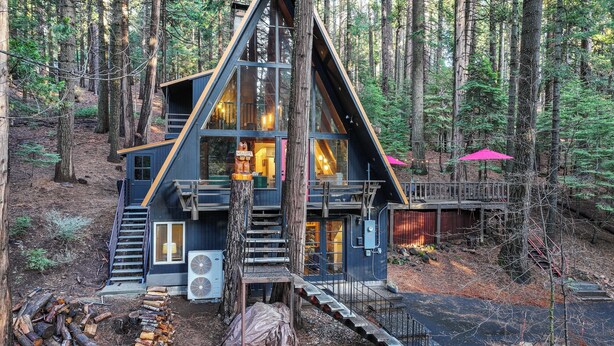 A cabin with a steeply pitched roof, large windows, and a wooden deck. - 3 Mi to Calaveras Big Trees: Cabin w/ Fire Pit! (Arnold)