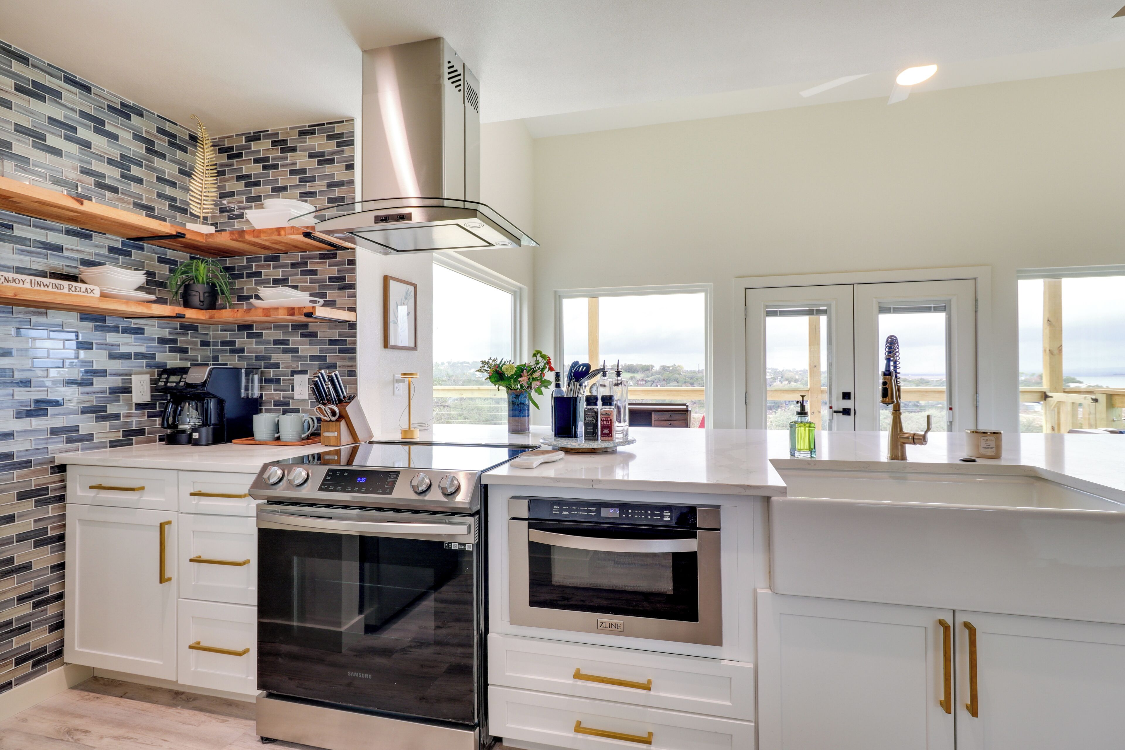 Una cocina moderna con una isla grande, electrodomésticos de acero inoxidable y vistas a la ciudad.