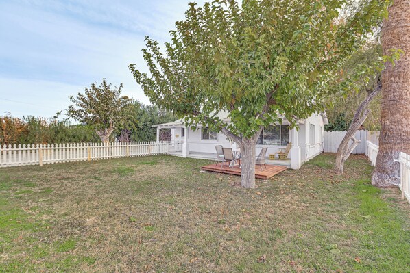 A white house with a deck, surrounded by a white picket fence, and a tree in the foreground. - 5 Mi to Dtwn: Pet-friendly Phoenix Gem w/ Patio (Phoenix)