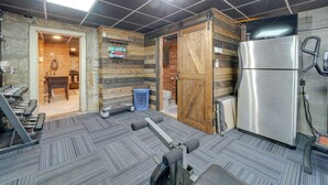 Una palestra con attrezzature per esercizi, un frigorifero e un pannello di legno.