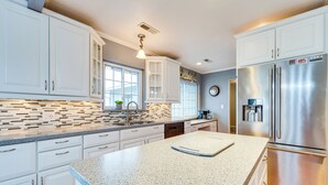 A modern kitchen with white cabinetry, a stainless steel refrigerator, and a granite countertop. - East Wenatchee Home ~ 2 Mi to Columbia River! (East Wenatchee)