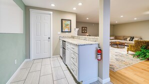 A kitchen with white cabinets, a white door, and a countertop. There is a fire extinguisher mounted on the wall. - East Wenatchee Home ~ 2 Mi to Columbia River! (East Wenatchee)
