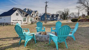 Un jardin avec un foyer et quatre chaises Adirondack.