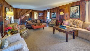 A spacious living room with a grand staircase, plush seating, and a fireplace. - Elegant Paris Manor w/ Private Pool! (Paris)