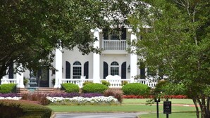 A large, white building with a symmetrical facade, arched windows, and a central entrance with steps.