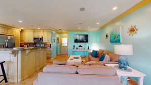 A spacious living area with a sofa, a coffee table, and a TV. - Augusta Antics 530 ~Golf Cart Included~Pet Friendly~Sandestin Resort (Miramar Beach)