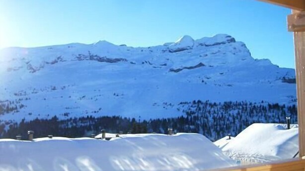 Eine Berglandschaft mit schneebedeckten Gipfeln und blauem Himmel.