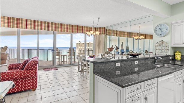 Una cocina moderna con una isla grande, un área de comedor con vistas y un balcón con vistas.