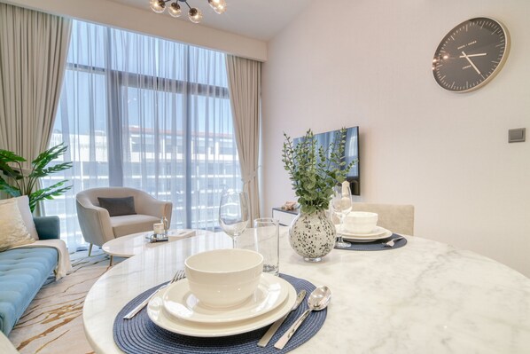 Relax in a stylish space with a sofa, armchairs, and dining table, offering a city view.