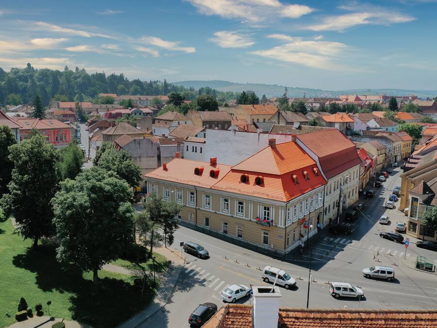 A town with historic buildings, a main street, and a green park area.