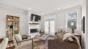 A modern living room with a fireplace, a television, and a comfortable seating area.