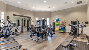 Et fitnesscenter med løbebånd, styrkemaskiner og træningsbolde.