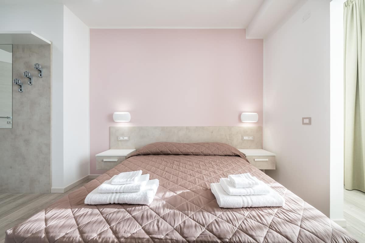 Un dormitorio moderno con una cama grande, dos mesitas de noche y un cabecero.
