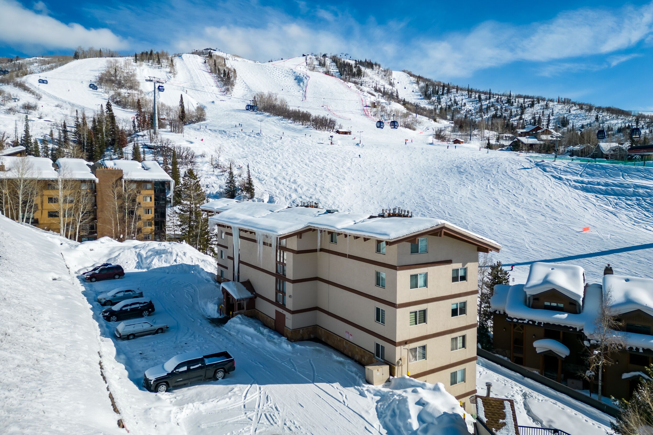 A multi-story hotel with a ski slope in the background.