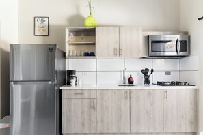 A modern kitchen with a stainless steel refrigerator, a microwave, and a coffee maker. - Chic 2BR Apartment w Free Parking near Palm Beach (Noord)